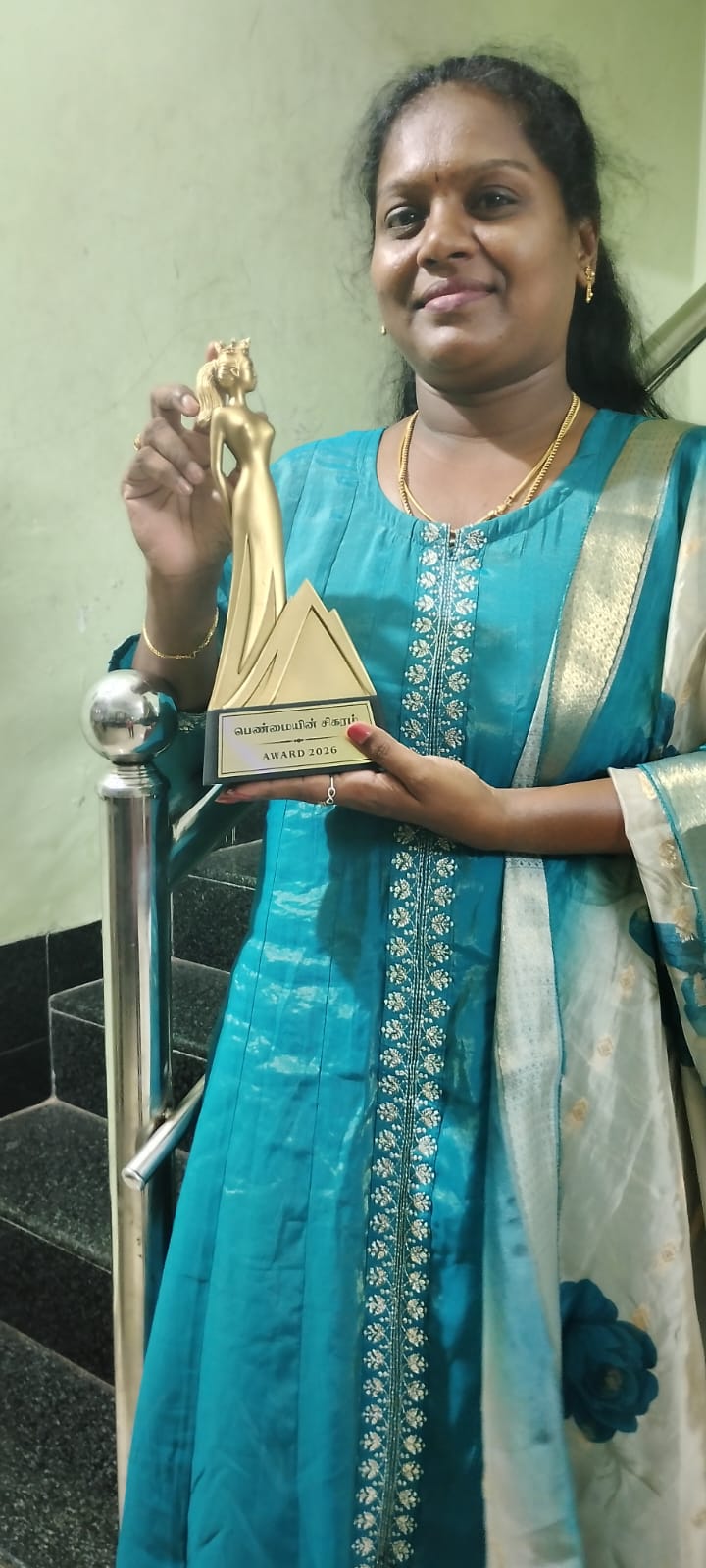 Vikom Vijayalakshmi proudly holding her award