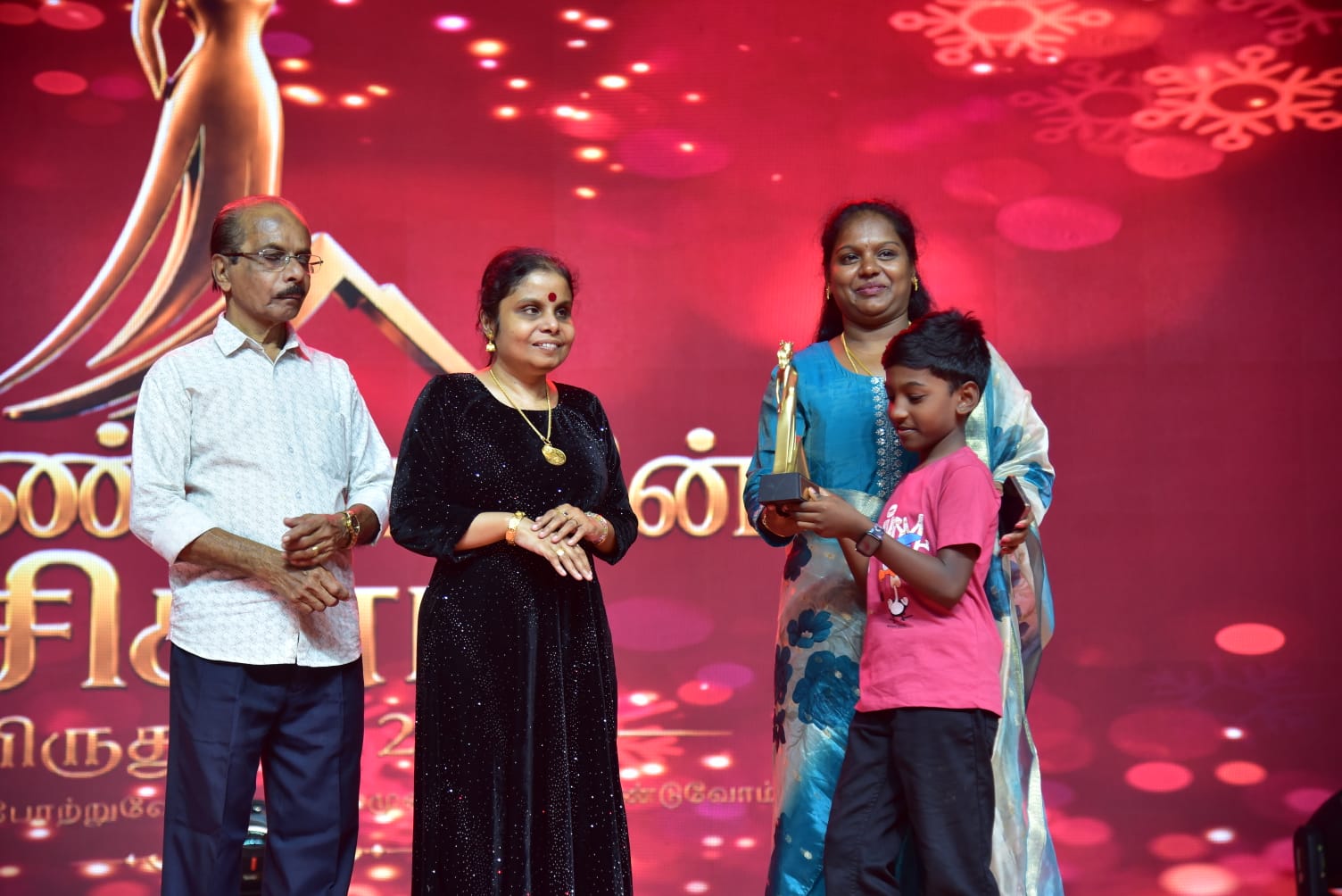 Vikom Vijayalakshmi and family smiling together on the award stage